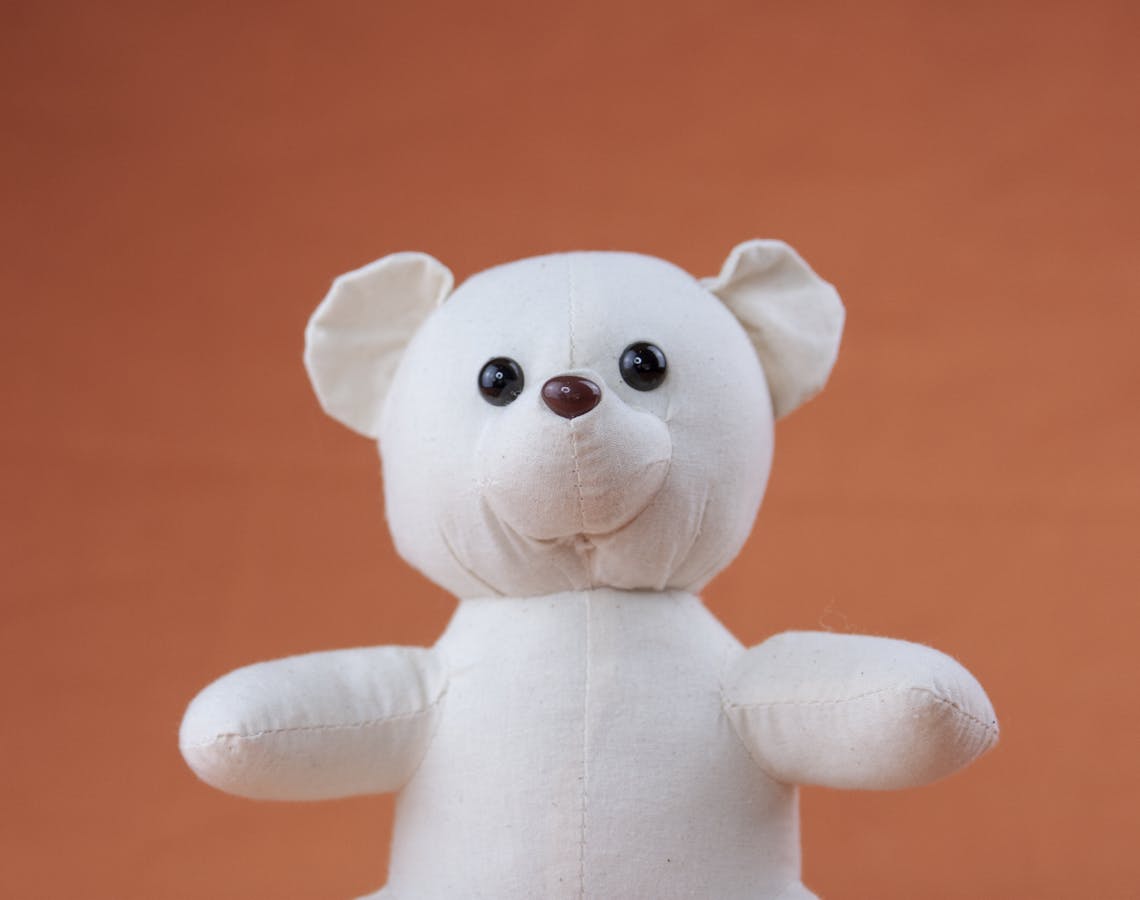 A White Plush Toy Bear on Orange Background