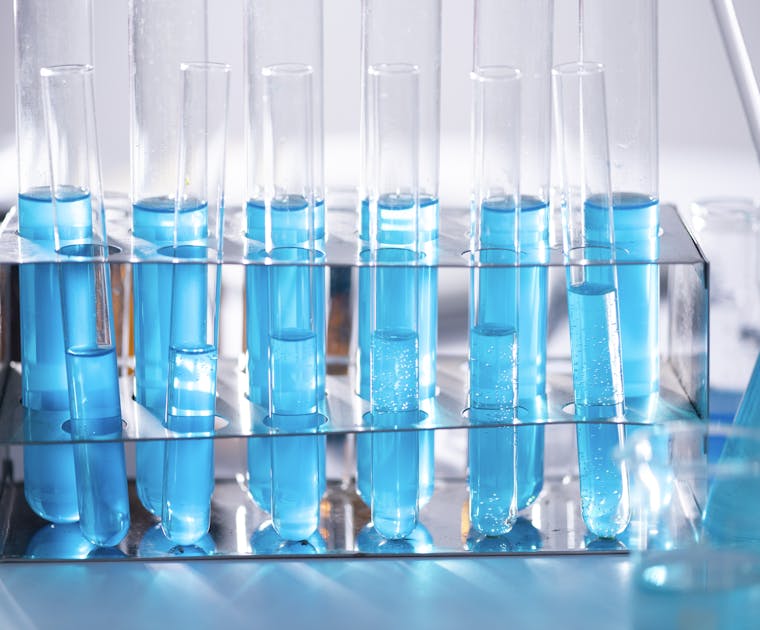 Close-up of blue liquid in test tubes for chemistry experiments in a laboratory setting.